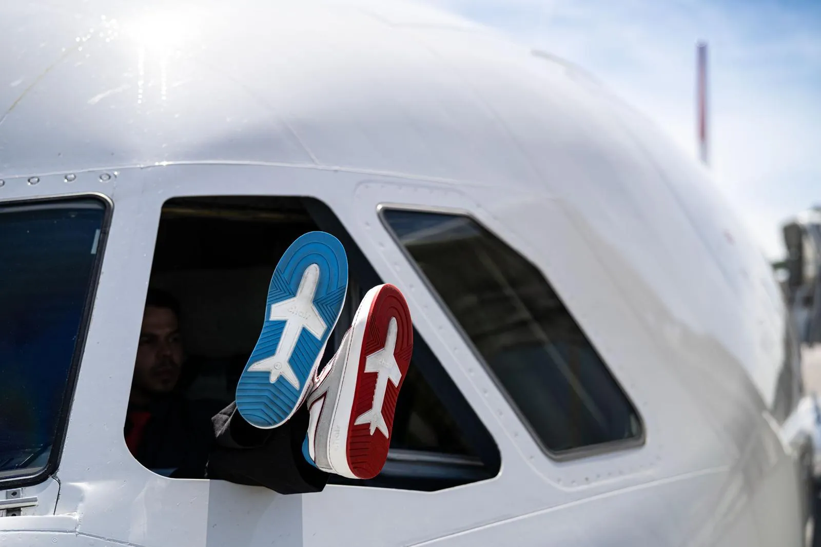 Pilotenfüße am Cockpitfenster, die Sohlen von Chair Airlines im Detail