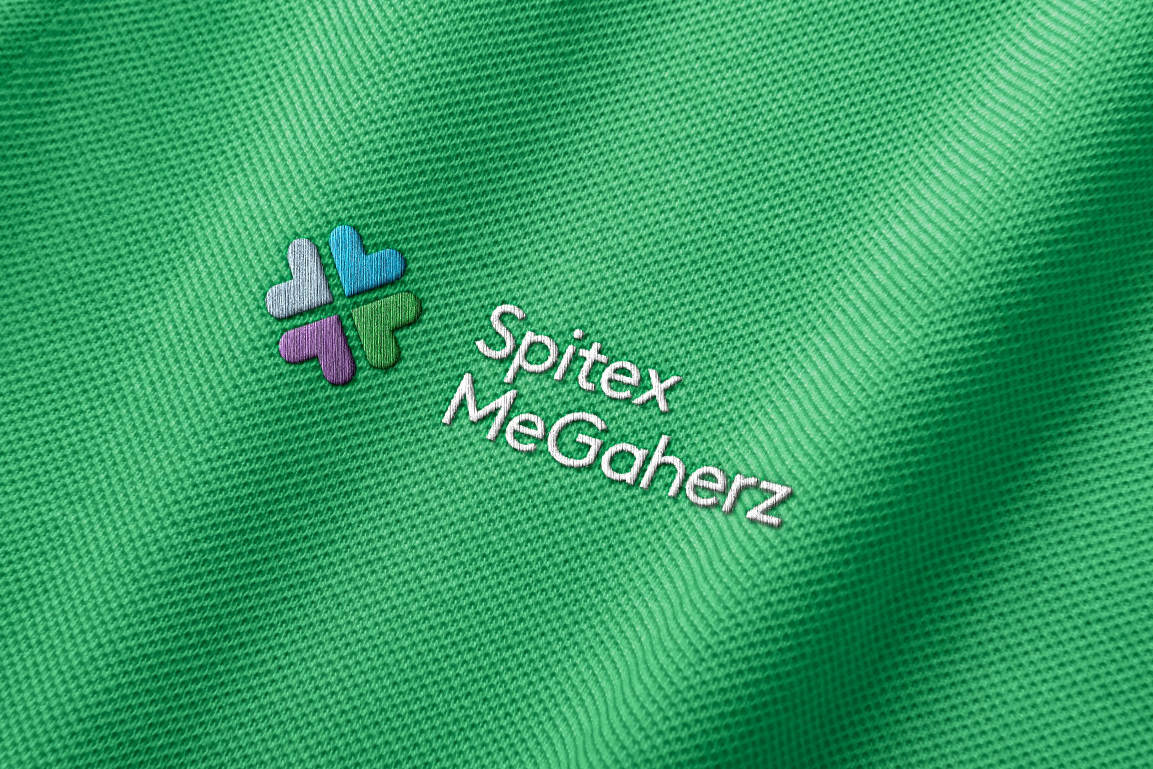 Gesticktes Markenzeichen von Spitex MeGaherz auf grünem Stoff im Detail